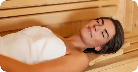 Woman relaxing in sauna with closed eyes